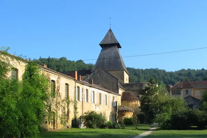 Le clocher et les bâtiments de l'abbaye de Cadouin au fond de son vallon
