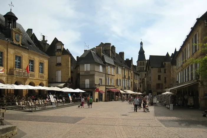 Une place du centre médiéval de Sarlat animée par les terrasses