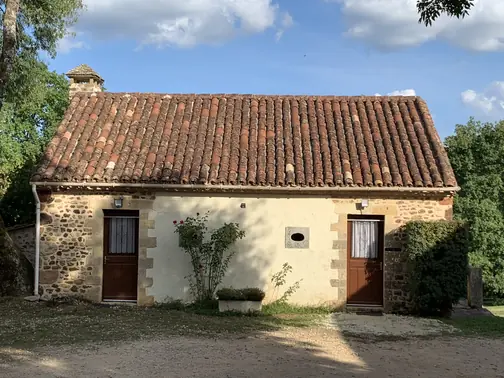 La façade en pierre du Fournil, ses deux portes et son rosier