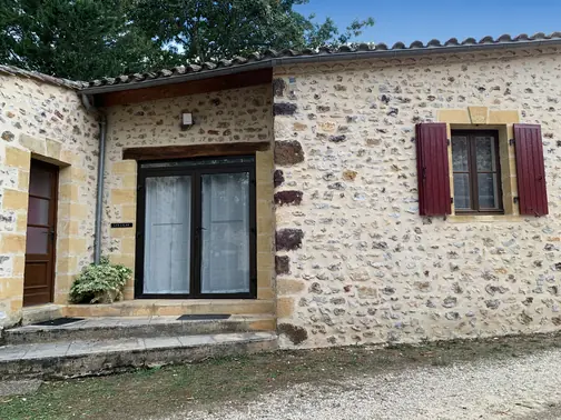 L'entrée des Lilas, sa porte-fenêtre et ses volets rouges